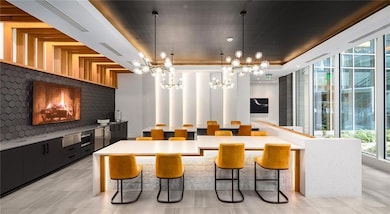 Kitchen featuring pendant lighting, dark cabinetry, a kitchen breakfast bar, plenty of natural light, and a wall of windows