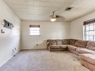 Carpeted living room featuring ceiling fan