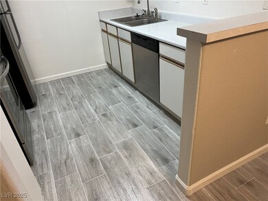 Kitchen with dishwasher, a sink, wood finish floor
