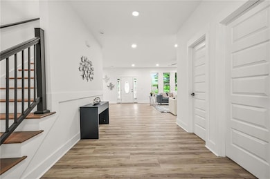 Corridor featuring recessed lighting, stairs, base