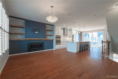 Unfurnished living room featuring dark hardwood /