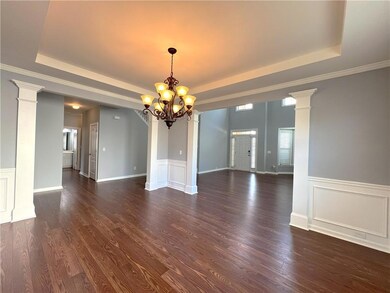 Unfurnished room with a tray ceiling, dark wood-st