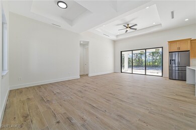 Unfurnished living room featuring baseboards, a tr