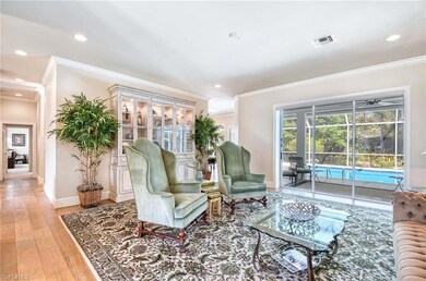 Living room with crown molding, hardwood flooring,