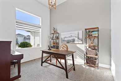Office space featuring light carpet, a chandelier, and a high ceiling
