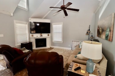 Living room featuring a ceiling fan, baseboards, h