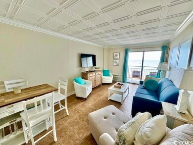 Living room featuring an ornate ceiling, tile patterned floors, crown molding, and baseboards
