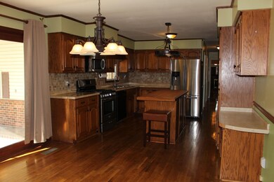 Spacious Eat in Kitchen w/ Oak Cabinets, Tiled Backsplash,  attached Dining Nook, and Hardwood flooring