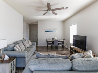 Living room featuring dark wood-type flooring and ceiling fan