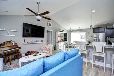 Living room with ceiling fan with notable chandeli