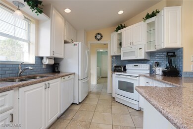 Kitchen with white cabinets, a sink, glass insert