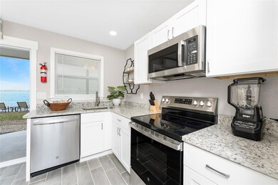 The updated kitchen features new cabinetry, granite countertops, and stainless steel appliances.