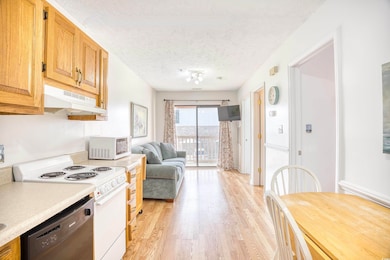 Kitchen featuring white appliances, a textured cei