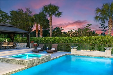 View of swimming pool featuring a patio area, a gazebo, fence, and a pool with connected hot tub