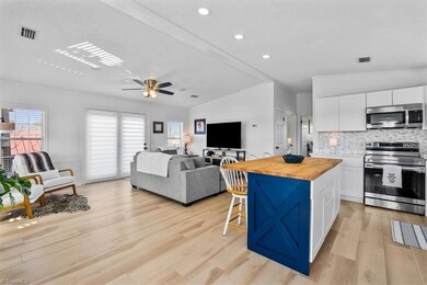Recently updated kitchen features island perfect for casual dining, recessed lighting, and tile backsplash.