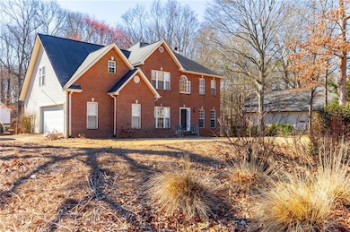 Colonial inspired home with brick siding and a gar