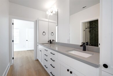 Bathroom with double vanity, wood finished floors