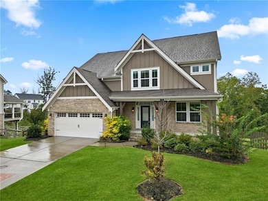 Craftsman house featuring board and batten siding, brick siding, a front lawn, and concrete driveway