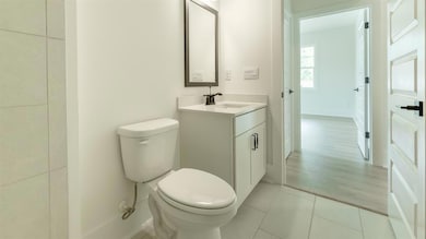 Bathroom with toilet, vanity, and tile patterned flooring