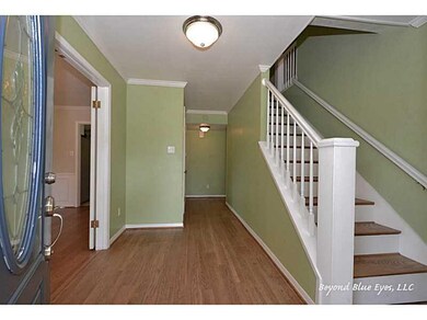 Photo. Foyer with half bath to right of stairs.