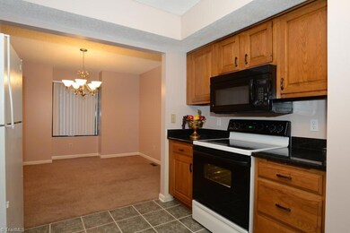 Tile floors in kitchen, more cabinets, with view toward formal dining room.