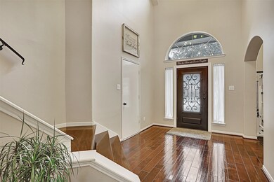 Alternate view of entry with ornate leaded glass door, arched entry to formal dining/flex room and door leading to garage.