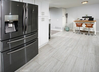 The cook in the family is going to truly appreciate the spacious remodeled kitchen with its sparkling picture windows,  recessed lighting, abundant white shaker cabinetry, handy pantry, durable dual basin stainless steel sink with modern faucet, Cori