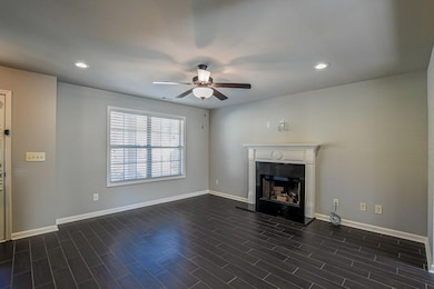 Unfurnished living room with recessed lighting, a fireplace with raised hearth, wood finish floors, and a ceiling fan