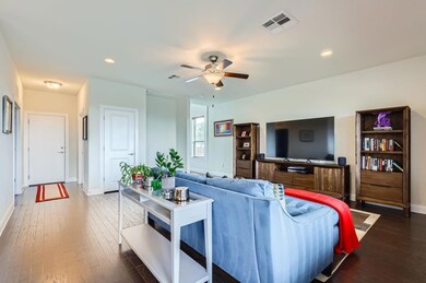 Living room featuring a ceiling fan, hardwood / w