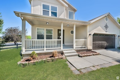 View of front of property featuring covered porch, stucco siding, a garage, concrete driveway, and a front lawn
