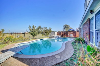 View of pool featuring a fenced backyard, a patio area, a pool with connected hot tub, and a diving board