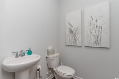 Half bathroom with baseboards, toilet, and a sink