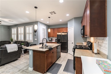 Kitchen with black appliances, a sink, tasteful ba