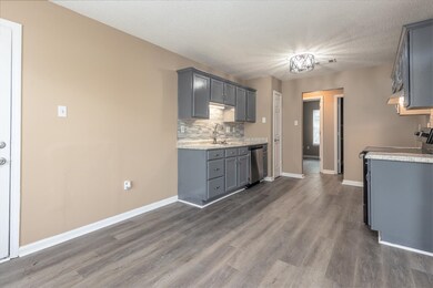 Kitchen featuring stainless steel dishwasher, dark hardwood / wood-style floors, and gray cabinetry