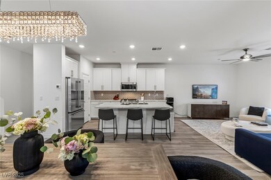 Kitchen with open floor plan, white cabinetry, tas