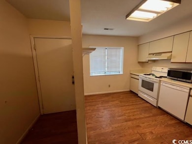 Kitchen featuring white appliances, white cabinets