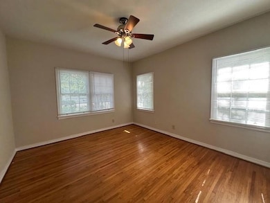 Spare room featuring wood finished floors, baseboards, and a ceiling fan