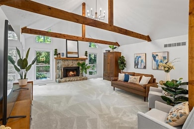 grand, vaulted ceilings with rustic wood beams, a beautiful new chandelier