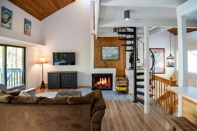 Open living design with woodburning fireplace and new flooring