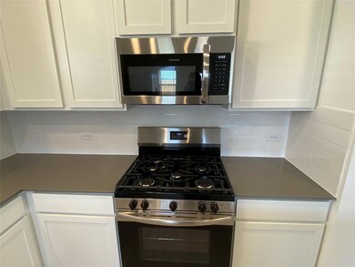 Kitchen featuring white cabinetry, appliances wit