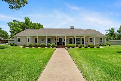 Ranch-style home with covered porch and a front y