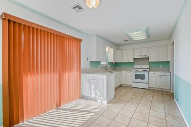 Kitchen featuring light tile flooring, white cabin