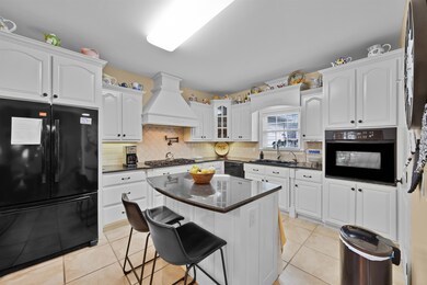 Kitchen with a breakfast bar, white cabinetry, sin