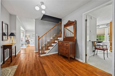 Staircase featuring hardwood / wood-style flooring and a textured ceiling