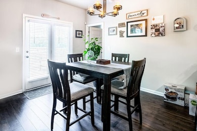 Dining room featuring dark wood-style floors and a chandelier