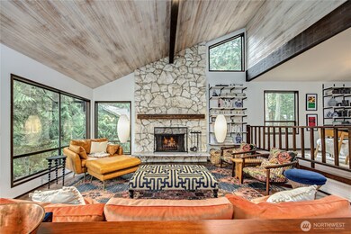 Wood fireplace with gorgeous stone surround anchors this large living room and gives a mid-century flair.