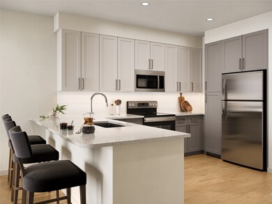 Kitchen featuring appliances with stainless steel finishes, gray cabinets, a peninsula, light wood finished floors, and a kitchen breakfast bar