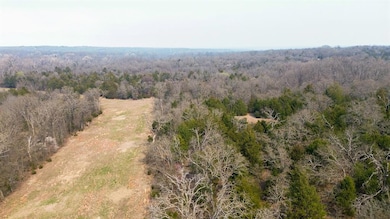 Birds eye view of property featuring a forest view