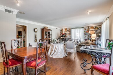 Dining area with crown molding, wood finished floors, and built in features