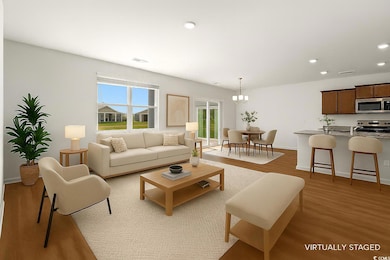 Living room with light wood finished floors, recessed lighting, and a chandelier